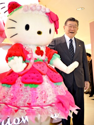 Shintaro Tsuji, presidente da Sanrio, criadora da Hello Kitty, posa ao lado de boneca da personagem (Foto:  AFP PHOTO/FILES/Yoshikazu TSUNO)