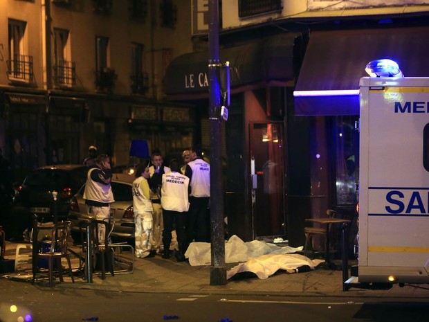 Corpos de vítimas de tiroteio foram cobertos na calçada em frente a um restaurante de Paris, na França (Foto: Philippe Wojazer/Reuters)