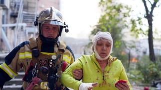 Uma moradora é socorrida após os ataques em Kiev. Prédios residenciais foram alvo de mísseis russos — Foto: HANDOUT / State Emergency Service of Ukraine / AFP