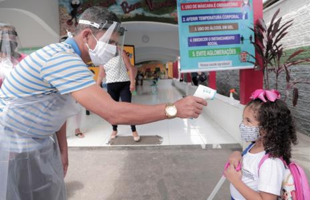 Servidor verifica temperatura de criança na entrada de escola em Araguaína — Foto: Marcos Sandes/Prefeitura de Araguaína