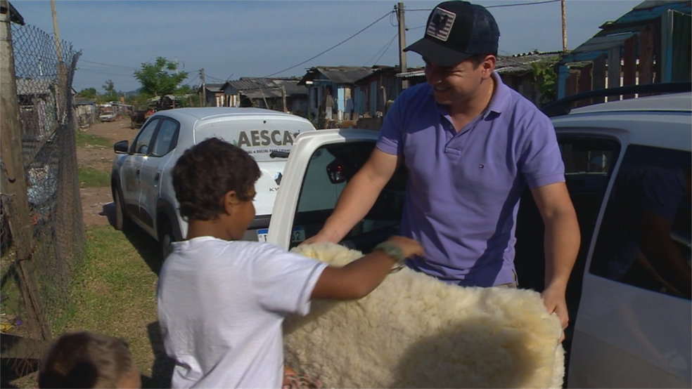Léo Paim entregou um pelego e sacos de milho para o menino. — Foto: Reprodução/RBS TV