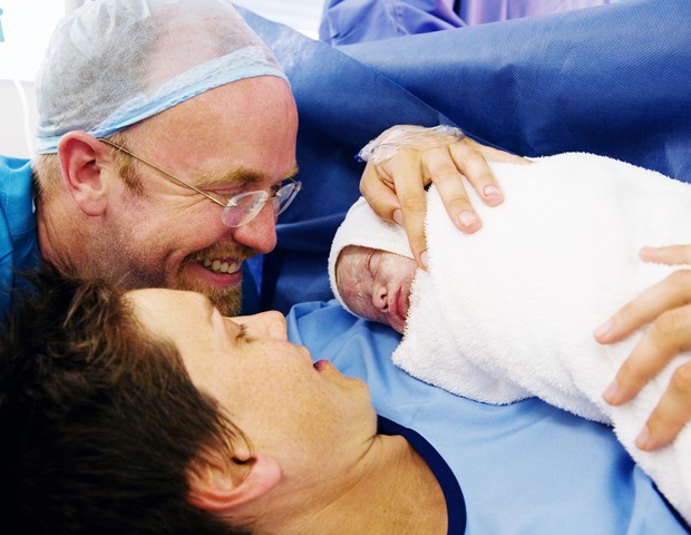 Mãe e pai veem recém-nascido pela primeira vez depois de uma cesárea (Foto: Getty Images)