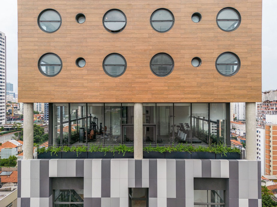Elementos modernistas, como formas orgânicas e pilotis, destacam-se na fachada