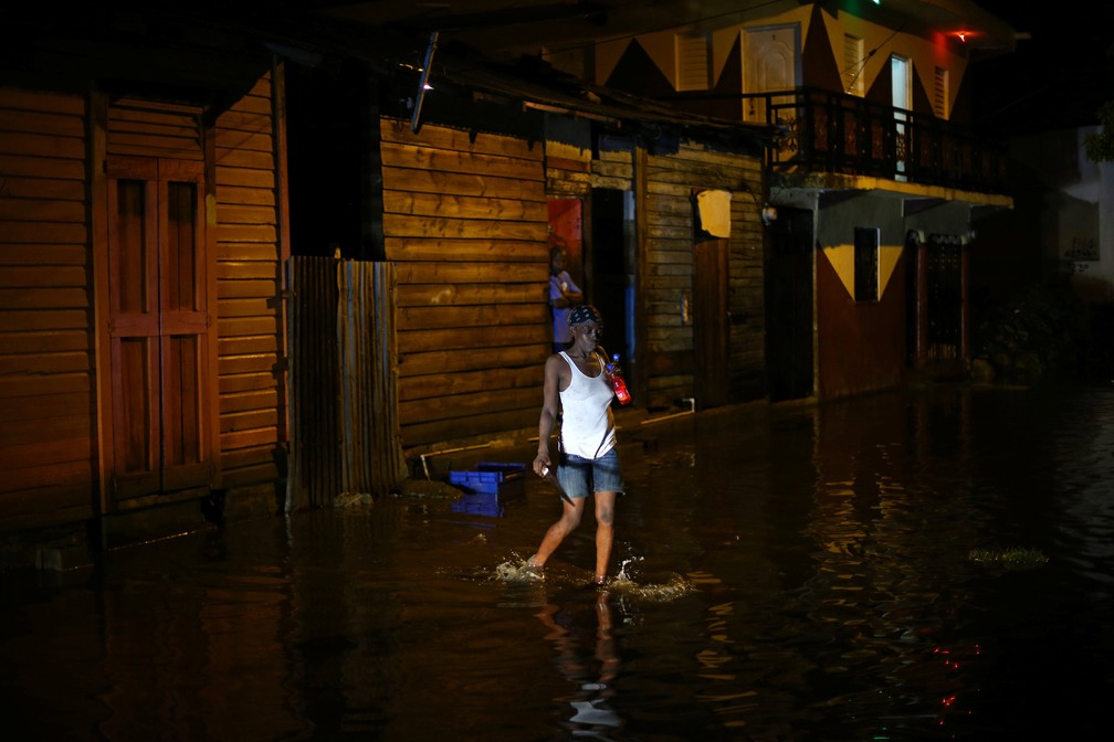 Mulher atravessa uma rua inundada em Puerto Plata, República Dominicana (Foto: Ivan Alvarado/Reuters)