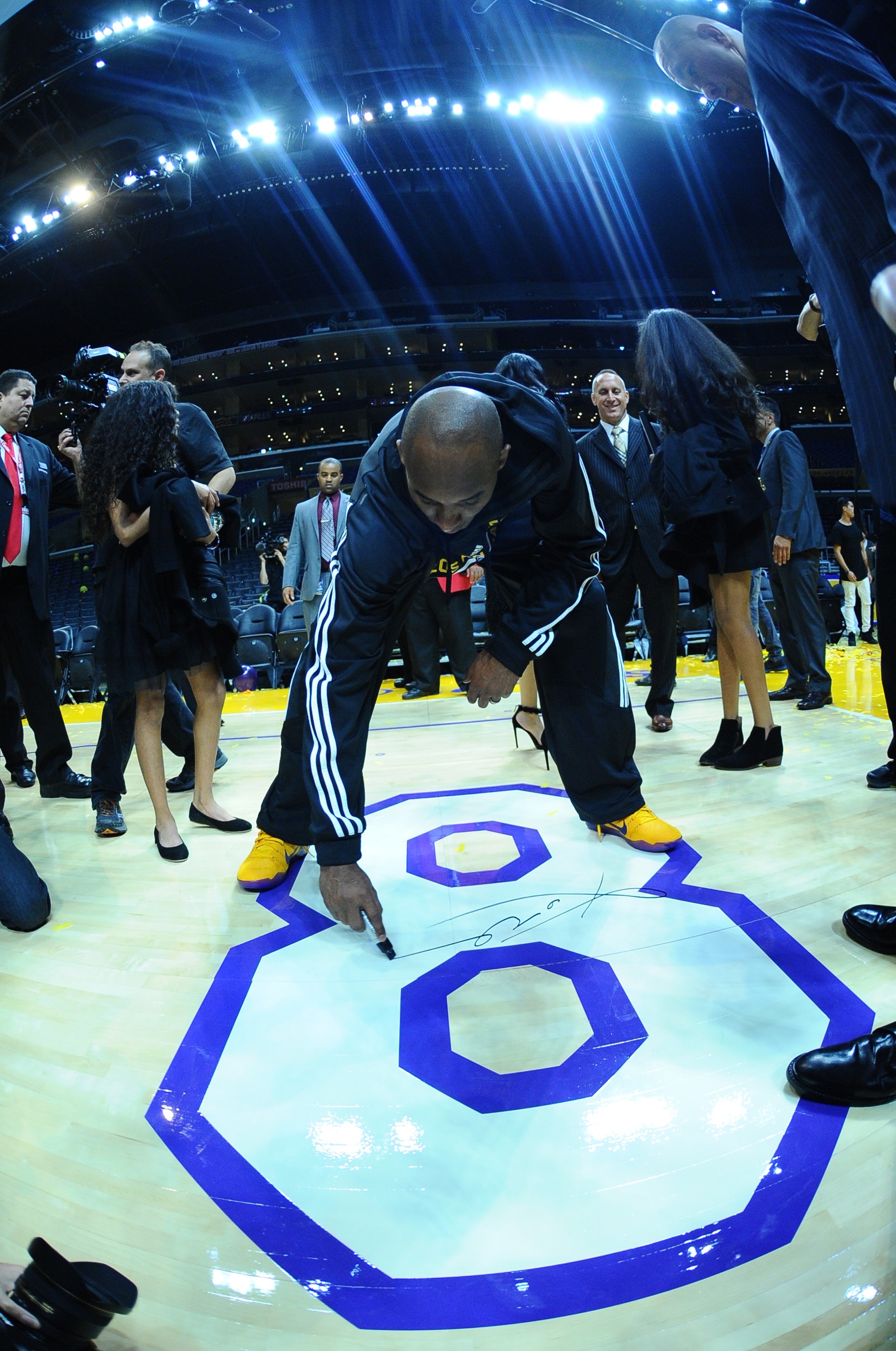 Kobe Bryant autografa piso de quadra (Foto: Getty Images)
