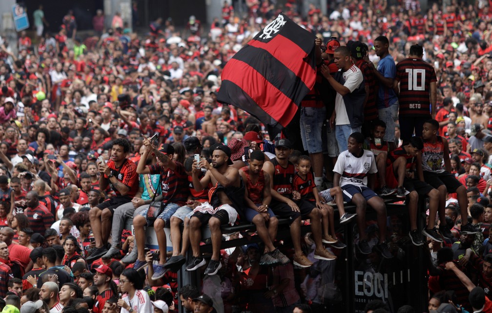 Torcedores sobem em um ponto de ônibus para tentar uma melhor visão dos ídolos — Foto: Ricardo Moraes/Reuters