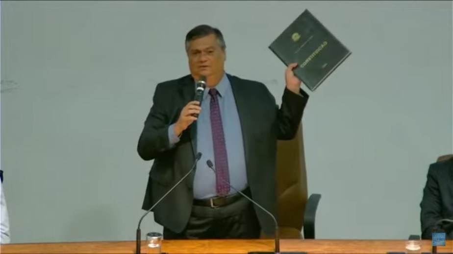 O ministro da Justiça, Flávio Dino, exibe cópia da Constituição que foi roubada do STF