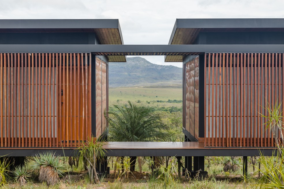 PASSARELA | Para integrar a paisagem, a casa seguiu um conceito linear e foi dividida em volumes separados — Foto: Bernardo Moreira / Divulgação