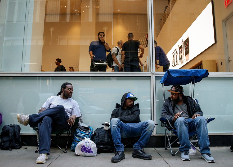 Três homens conversam enquanto esperam na fila para o novo iPhone em Nova York (Foto: Brendan McDermid/ Reuters)
