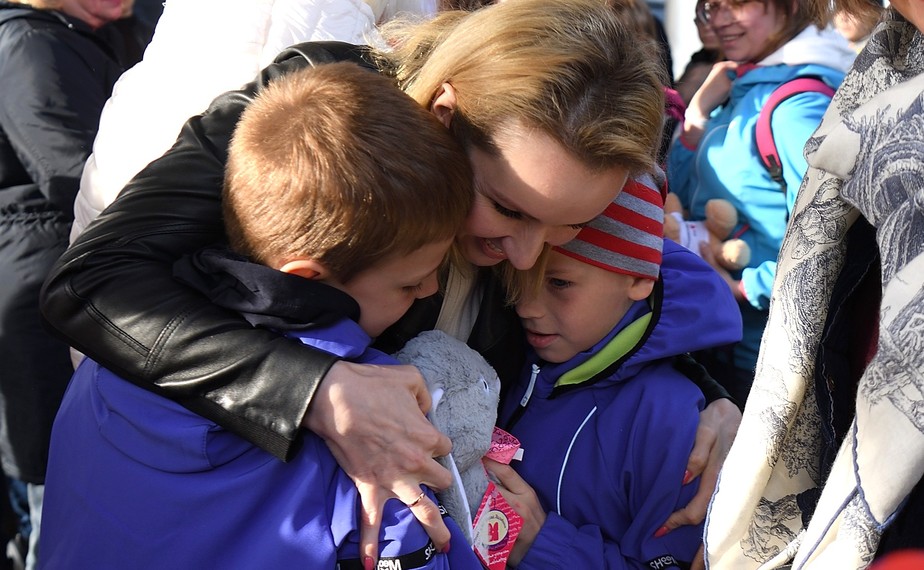Maria Lvova-Belova abraça crianças supostamente órfãs de Donbass postas sob os cuidados de famílias adotivas na Rússia