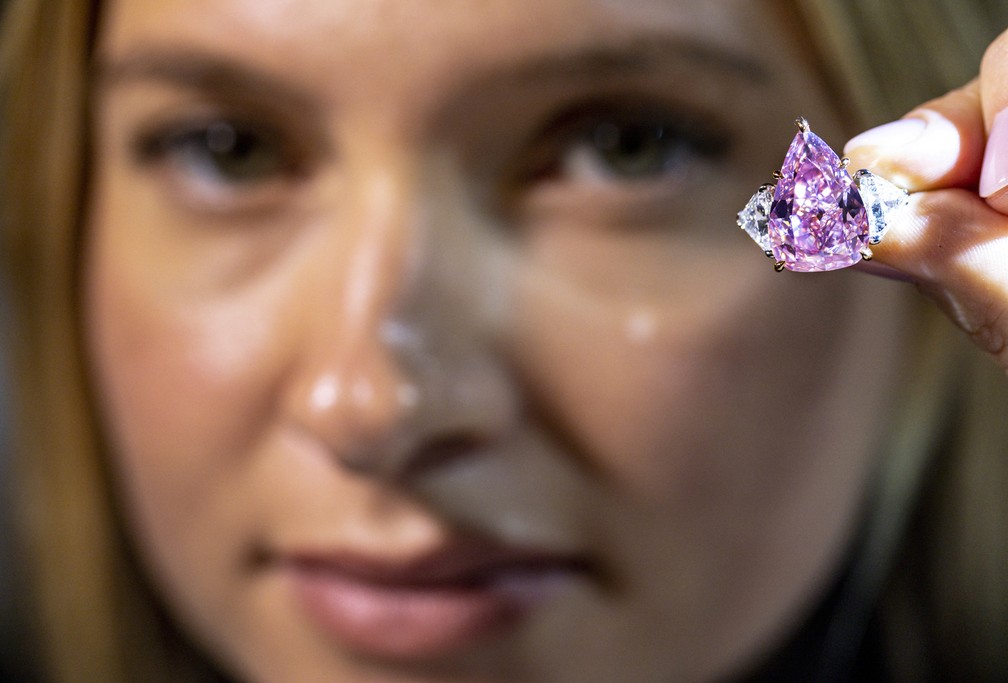 Uma modelo segura um diamante rosa de 18,18 quilates chamado "Fortune Pink" — Foto: Denis Balibouse/REUTERS