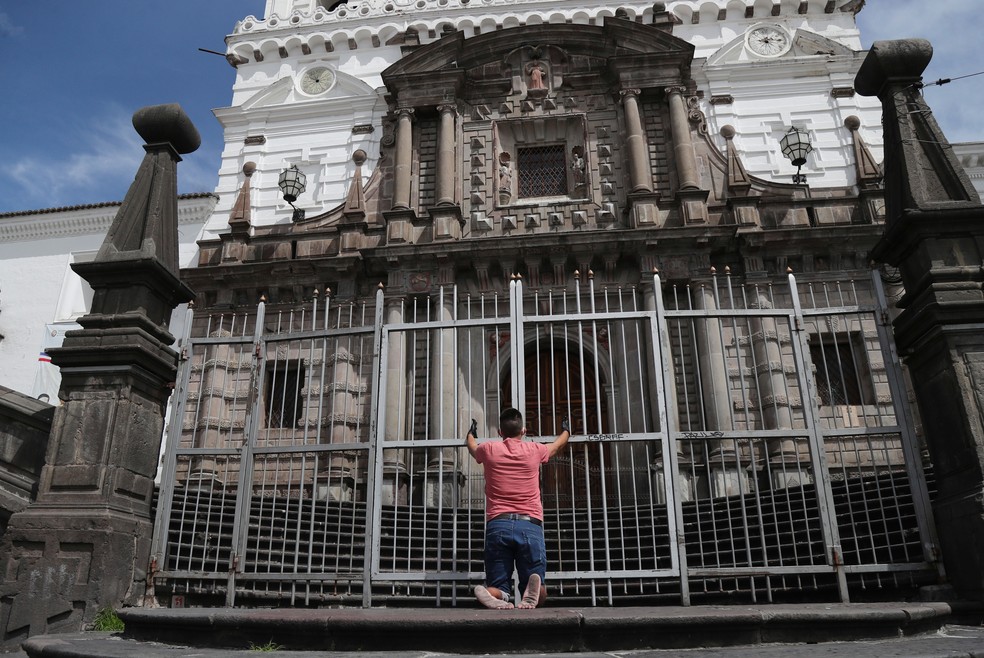 Homem reza em frente à igreja de São Francisco, na sexta-feira (10), em Quito, no Equador  — Foto: Dolores Ochoa/ AP 