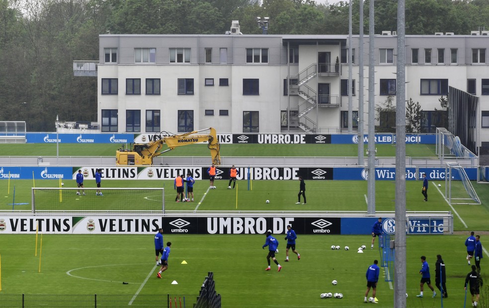 Jogadores do Schalke, divididos em grupos, treinam respeitando o distanciamento social — Foto: AFP