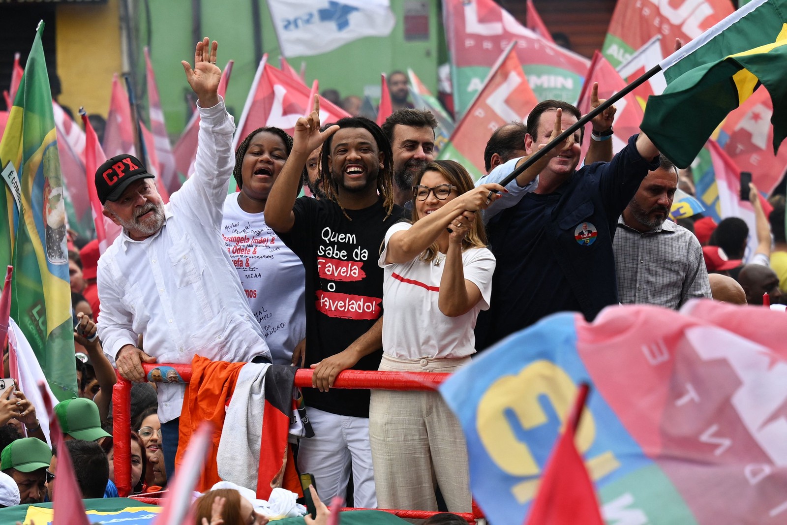 Lula desfila em carro aberto desfilando pelo Complexo do Alemão ao lado de moradores — Foto: Carl de Souza/AFP
