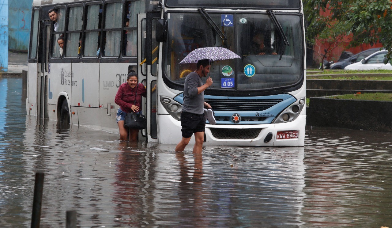 Ônibus com passageiros enguiça ao tentar passar pela Estrada de Jacarepaguá, na Muzema — Foto: Fabiano Rocha / Agência O Globo