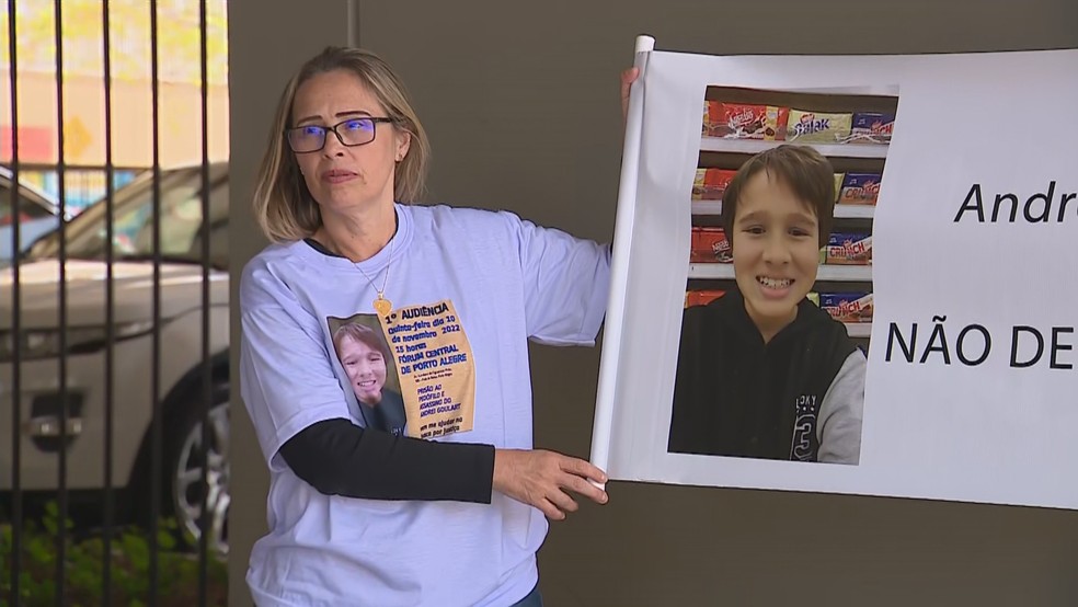 Mãe de Andrei mostra faixa com foto do filho em Porto Alegre — Foto: Reprodução/RBS TV