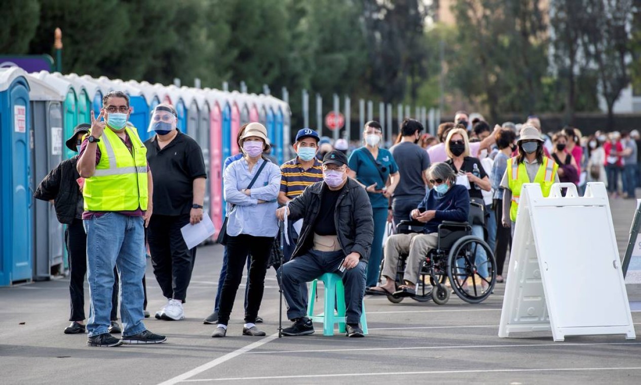Pessoas esperam na fila em um estacionamento da Disneylândia para receber as vacinas contra a Covid-19 no parque temático, em Anaheim, Califórnia, EUA — Foto: VALERIE MACON / AFP - 14/01/2021