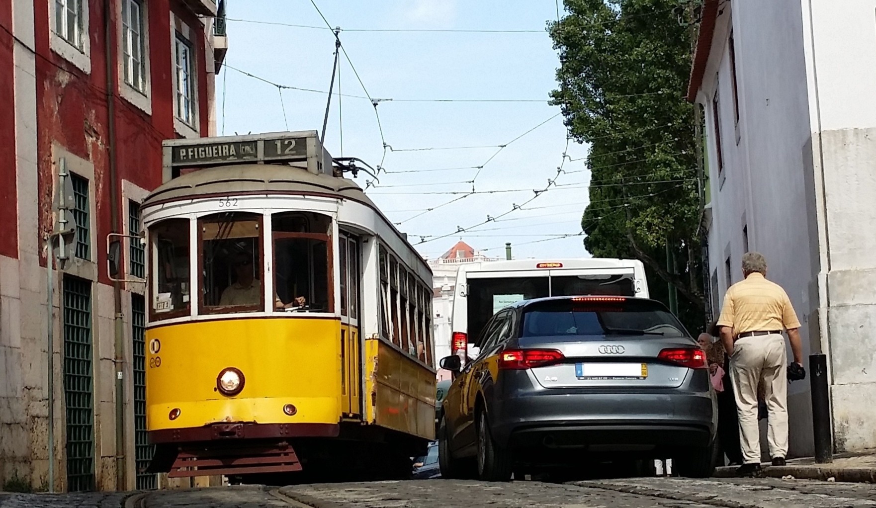 Bondinho e carro disputam espaço numa rua de Alfama, em Lisboa