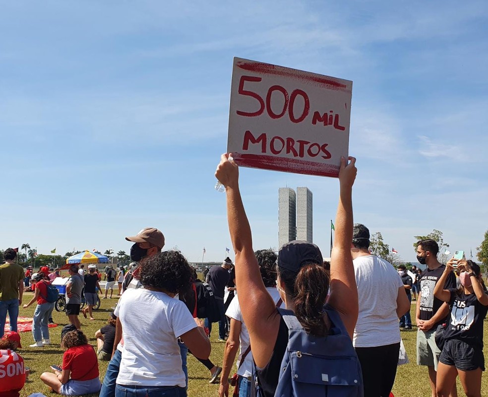 Mulher segura cartaz em referência a marca de 500 mil mortes por Covid-19 no Brasil, durante protesto contra governo Bolsonaro, no DF — Foto: Anna Reis/ TV Globo