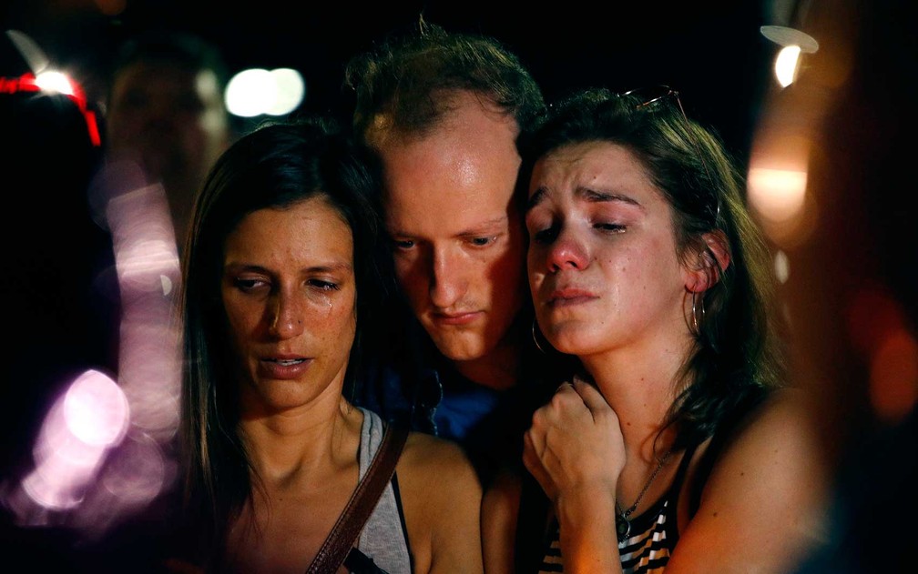 Mallory Cunningham (Ã  esquerda), Santino Tomasetti (centro) e Aubrey Reece se emocionam durante vigÃ­lia no Missouri (Foto: Charlie Riedel / AP Photo)