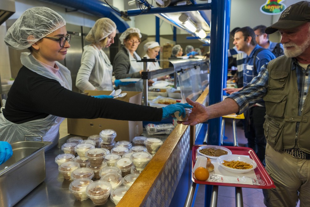 Homem recebe sorvete em cantina da entidade assistencial Caritas em Roma (Foto: AP/Andrew Medichini)