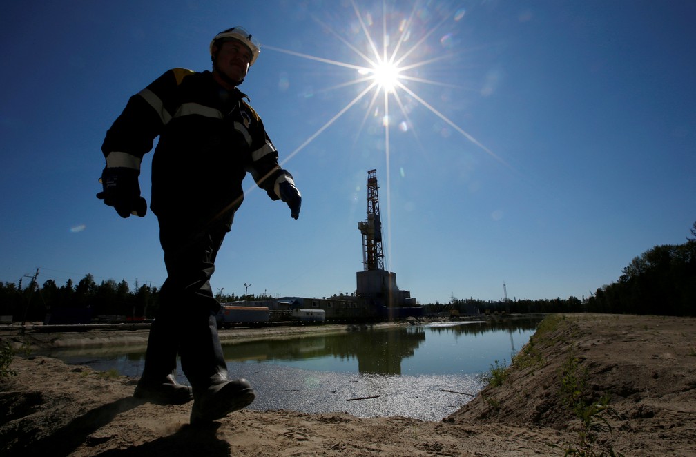Trabalhador caminha por campo de petróleo na cidade de Nefteyugansk, na Rússia — Foto: Reuters/Sergei Karpukhin