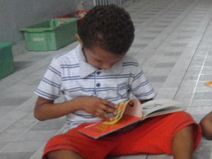 Criança lê durante visita do projeto Leitura em Roda (Foto: Juliana Barros/Livro em Roda)