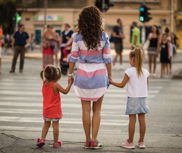Stop at the traffic light for your safety. Mother walking with her daughter walking over the pedestrian crossing. From back. Close up. Copy space. (Foto: Getty Images/iStockphoto)