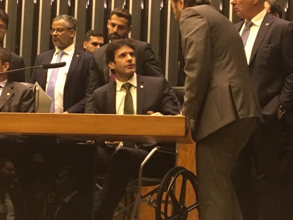 O ministro do Turismo, Marcelo Ãlvaro AntÃ´nio, ao tomar posse como deputado em cadeira de rodas â Foto: Fernanda Vivas / TV Globo