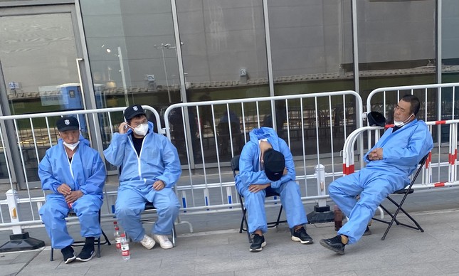 Fadiga: servidores em posto de testagem de Pequim durante uma pausa