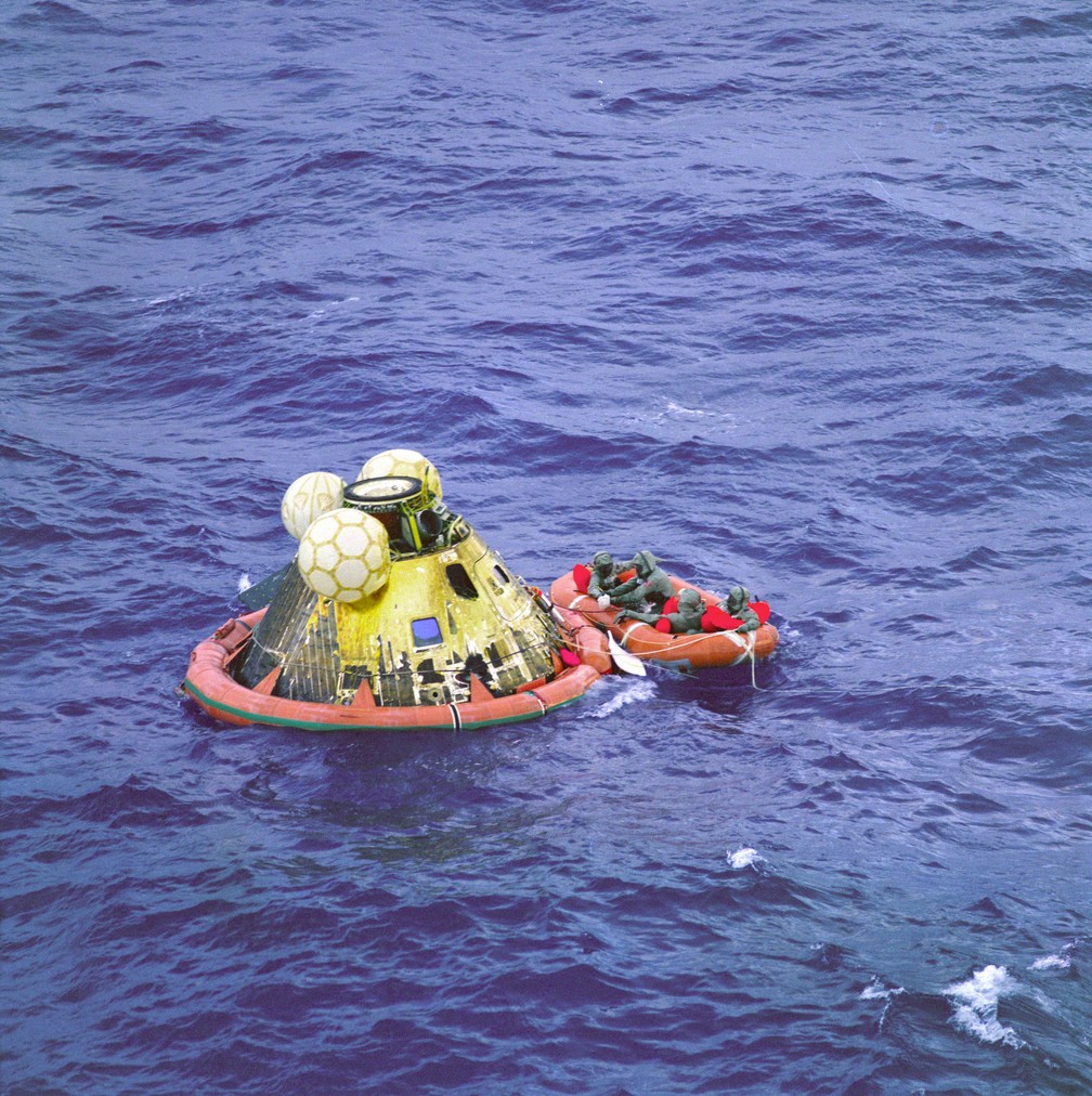 Os astronautas da Apollo 11 pousaram nas águas no norte do Oceano Pacífico; usando vestimentas de isolamento por prevenção de possíveis contaminações da ida à Lua, eles foram resgatados por um nadador da Marinha dos EUA e depois levados de helicóptero para o continente — Foto: Divulgação/Nasa