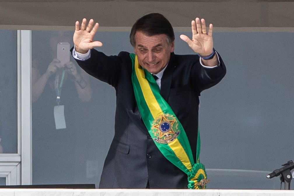 Do Parlatório, o presidente Jair Bolsonaro saúda o público na Praça dos Três Poderes — Foto: Fábio Tito/G1