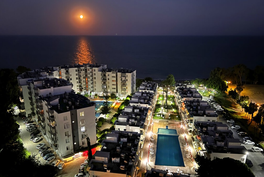 Superlua dos Cervos sobre o Mar Mediterrâneo, em frente a um complexo residencial, na cidade costeira de Mersin, na Turquia — Foto: AP