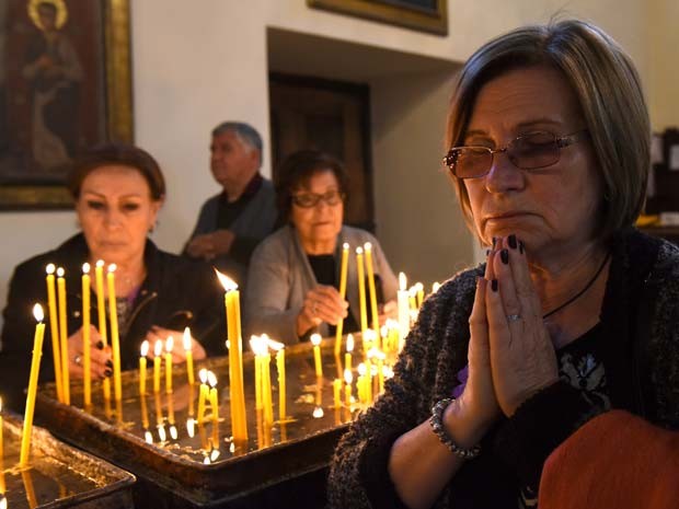 Mulher reza durante cerimônia pelos armênios vítimas dos massacres na catedral de Etchmiadzin, em Erevan (Foto: AFP PHOTO / KAREN MINASYAN)