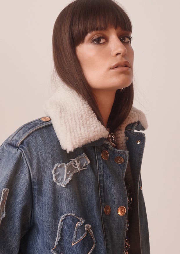 Clara Luciani usa jaqueta jeans e top de couro estampado. Todas as peças são da coleção Métiers D’Art Paris-New York 2018/19 da Chanel (Foto: Sascha Heintze)