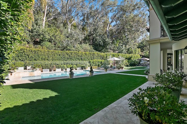 Na ampla área externa a mansão conta com piscina, spa, churrasqueira e um grande jardim com gramado (Foto: Sotheby’s International Realty / Divulgação)