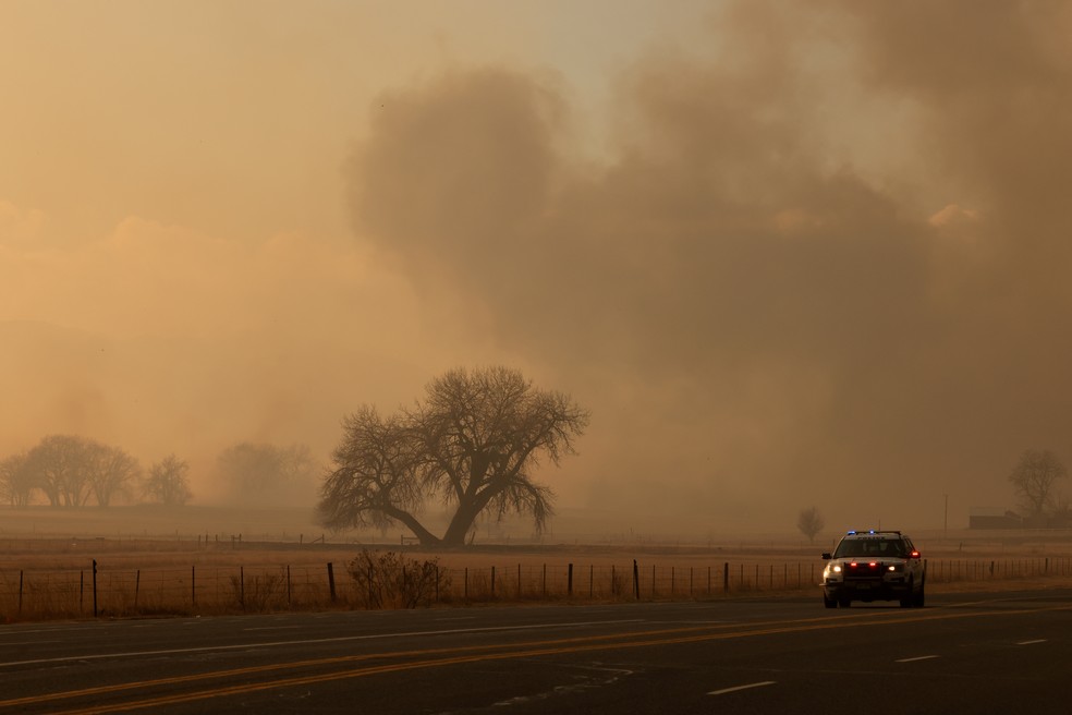 Um veículo da polícia passa na estrada depois que incêndios florestais movidos pelos vento causaram ordens de evacuação, perto de Boulder, Colorado, nos EUA. 30/12/2021 — Foto: Kevin Mohatt/Reuters