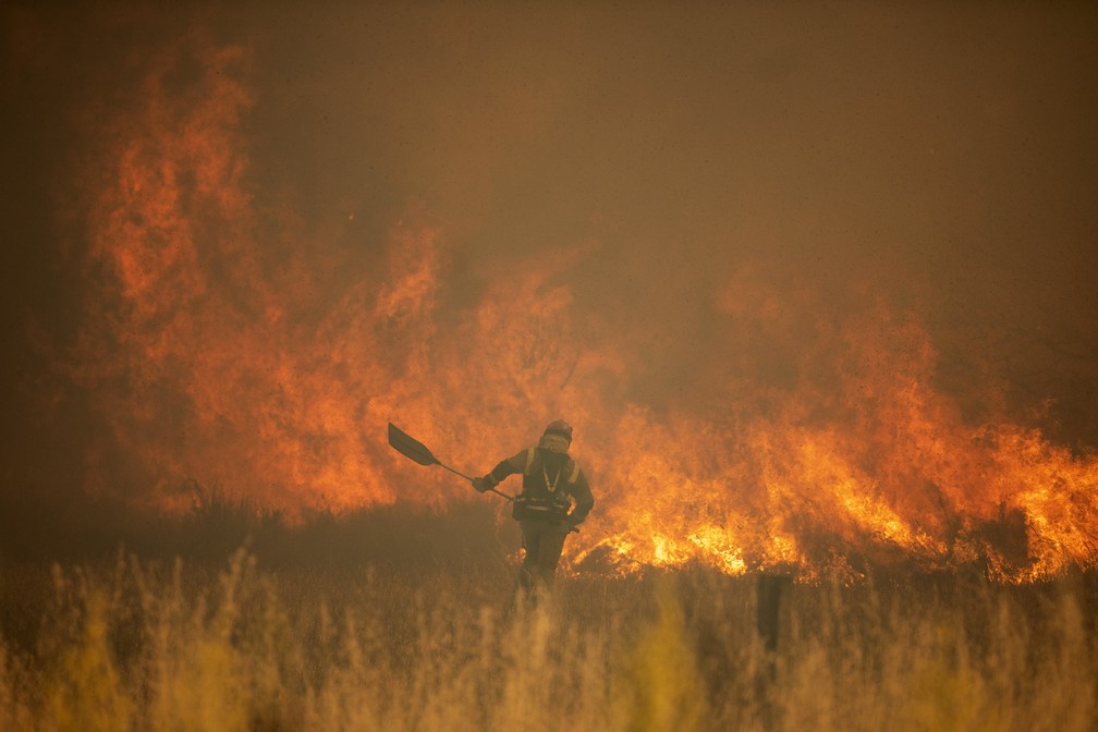 Um bombeiro trabalha em frente às chamas durante um incêndio florestal em Sierra de la Culebra, em Zamora, Espanha (18/06/22). — Foto: Emilio Fraile/Europa Press via AP