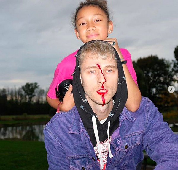 O músico Machine Gun Kelly com o rosto ensanguentado na companhia da filha (Foto: Instagram)