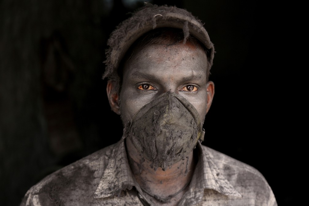 30 de abril - Trabalhador indiano usa máscara de proteção desgastada enquanto trabalha em uma pequena fábrica de alumínio, em Hyderabad, na Índia — Foto: Mahesh Kumar A./AP