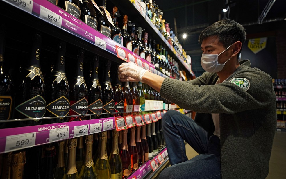  Funcionário organiza prateleira com garrafas de vinho espumante russo em supermercado em Moscou, em 5 de julho — Foto: Reuters/Tatyana Makeyeva 