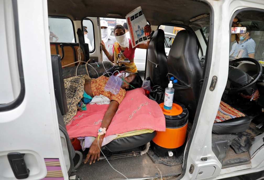Mulher recebe oxigênio dentro de carro enquanto espera por tratamento para Covid-19 em hospital de Ahmedabad, na Índia, em foto desta segunda-feira (26) — Foto: Amit Dave/Reuters
