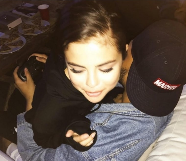 A cantora Selena Gomez nos braços de The Weeknd enquanto ele joga videogame (Foto: Instagram)