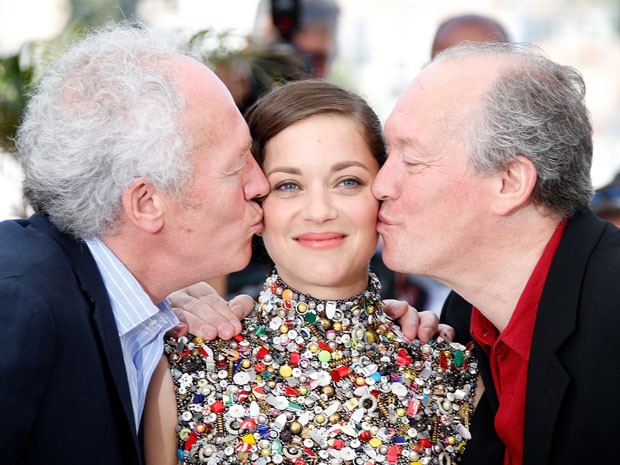 A atriz francesa Marion Cotillard recebe beijo dos irmãos Dardenne, Luc (à dir.) e Jean-Pierre (à esq.), durante apresentação do filme 'Deux jours, une nuit' no Festival de Cannes nesta terça-feira (20) (Foto: Valery Hache/AFP)