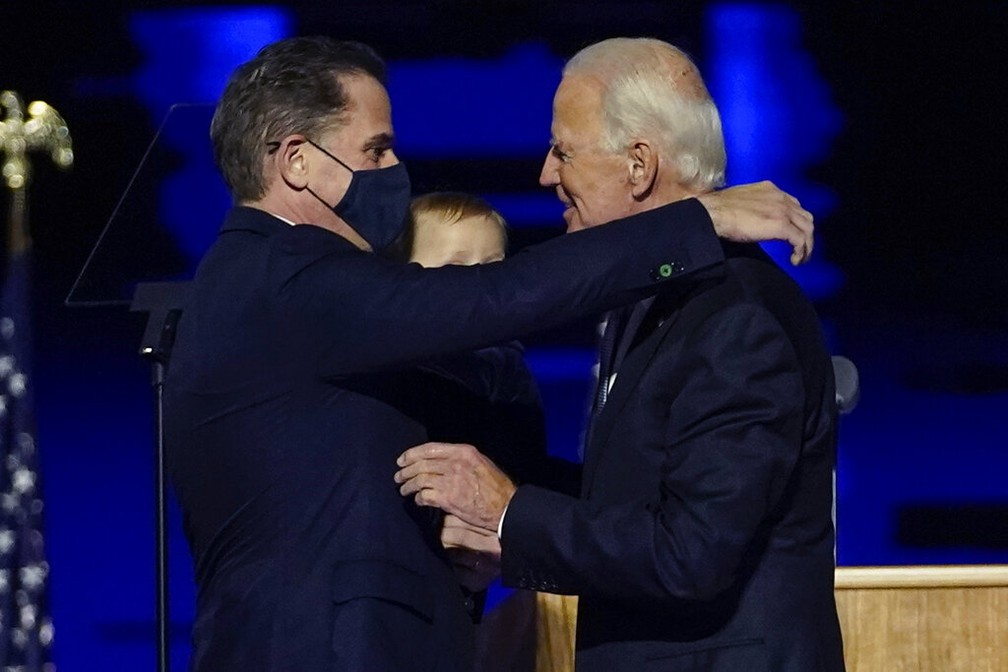 Hunter Biden, de máscara, abraça o pai, Joe Biden, durante evento em Wilmington em 7 de novembro — Foto: Andrew Harnik, Arquivo/AP Photo