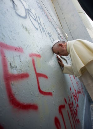 O Papa Francisco ora na barreira de segurança entre Israel e a Cisjordânia, neste domingo (25) (Foto: AFP/Osservatore Romano)