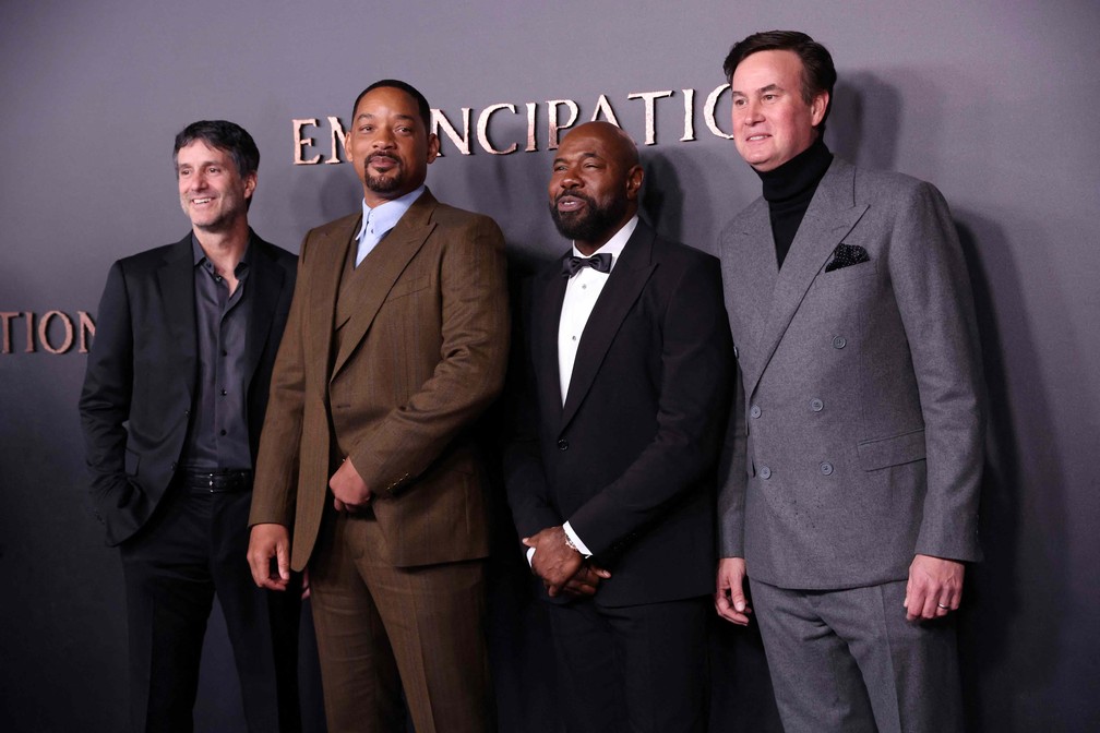  Jamie Erlicht, codiretor de programação da Apple, o ator Will Smith, o diretor Antoine Fuqua e o também codiretor de programação da Apple Zack Van Amburg durante a entrada da premiere europeia de 'Emancipation', no dia 2 de dezembro, em Londres — Foto: Isabel Infantes/AFP