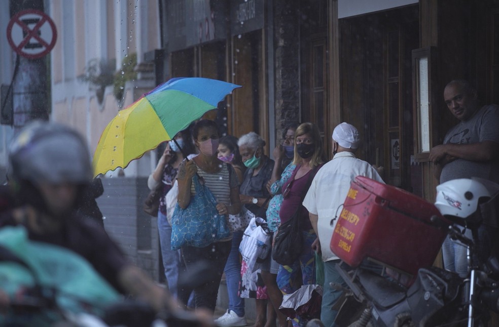 Moradores tentam se proteger da chuva no bairro Valparaíso  — Foto: Marcos Serra Lima/g1 