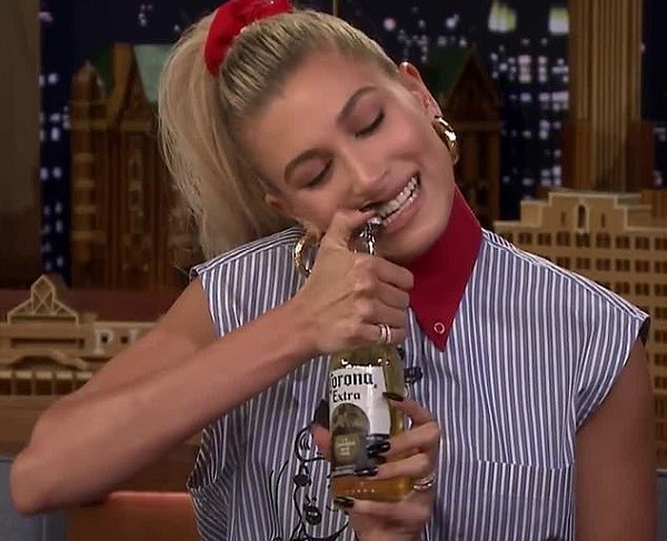 Hailey Baldwin abrindo garrafa de cerveja com os dentes em 2018 (Foto: Reprodução)