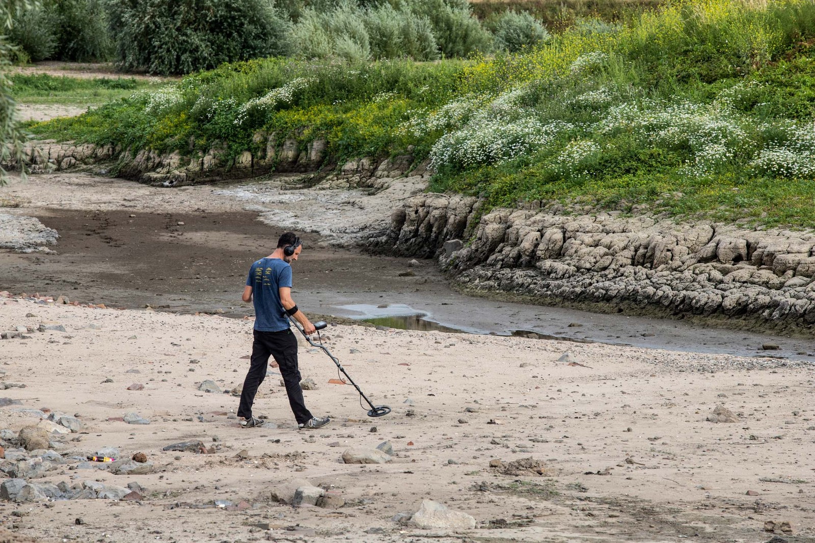 Homem com detector de metais no rio Reno em Lobith, na Holanda, em 30 de julho — Foto: Peter Boer / Bloomberg